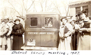 Group of women standing next to bookmobile 