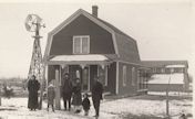 Family in front of wooden house