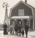 Family in front of wooden house
