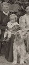 People and dogs in front of sod house