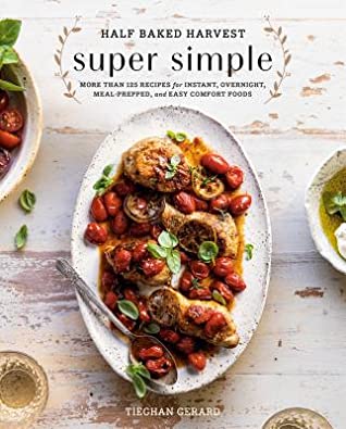 Book cover with title "Half Baked Harvest Super Simple More than 125 recipes for instant, overnight, meal-prepped, and easy comfort foods" on top. Author Tieghan Gerard on bottom. Image in center of oval serving dish with chicken, lemon slices, and cherry tomatoes.
